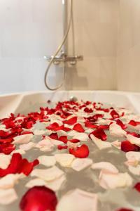 a bunch of red rose petals on a bath tub at Henry Crown Hotel in Thôn Trường Giang
