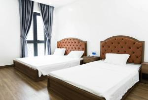 a bedroom with two beds and a window at Henry Crown Hotel in Thôn Trường Giang