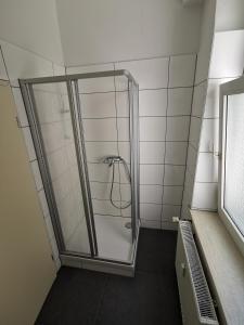 a shower with a glass door in a bathroom at Ferdimesse Apartments in Cologne