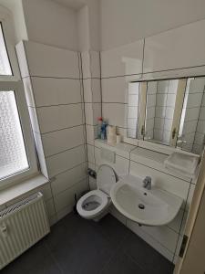 a bathroom with a white toilet and a sink at Ferdimesse Apartments in Cologne