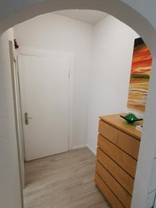 een kamer met een witte deur en een houten dressoir bij Ferdimesse Apartments in Keulen