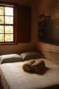 Una cama con una toalla en un dormitorio en Nuh Hostel en Ouro Preto