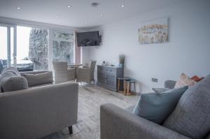 a living room with two couches and a tv at Beach Court - 1 Bedroom Apartment - Saundersfoot in Saundersfoot