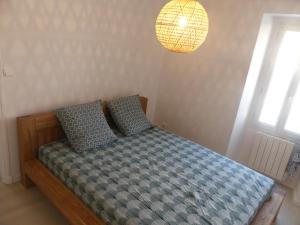 1 dormitorio con cama y lámpara en Superbe Maison Rénovée en Centre-ville en Saint-Pierre-dʼOléron