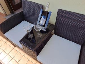 een tafel met twee glazen en flessen wijn bij Appartamento Roverella in Rovigo