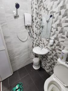 La salle de bains est pourvue de toilettes et d'un lavabo. dans l'établissement SinggahSini Homestay Melaka, 