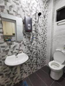 La salle de bains est pourvue de toilettes et d'un lavabo. dans l'établissement SinggahSini Homestay Melaka, 