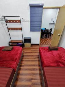 - 2 lits dans une chambre avec salle à manger dans l'établissement SinggahSini Homestay Melaka, 