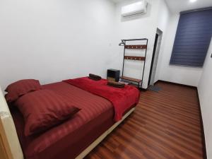 - une chambre avec un lit et une couette rouge dans l'établissement SinggahSini Homestay Melaka, 