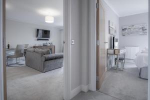 Una sala de estar con un sofá y un comedor. en Upper Deck - 2 Bedroom Apartment - Saundersfoot, en Saundersfoot