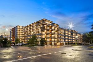 a large apartment building in a parking lot at New 2 Bed 2 Bath Apt at The Heart of Canberra - 2 Car Spaces in Canberra