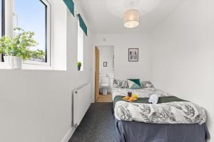 a white bedroom with a bed and a window at Silver Stag Properties, Self-Contained Suite in Donisthorpe