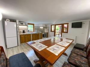 a kitchen with a wooden table and a refrigerator at Casa cu vitralii in Slănic-Moldova