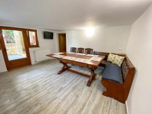 a dining room with a wooden table and chairs at Casa cu vitralii in Slănic-Moldova