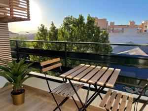 una panca di legno seduta su un balcone con una pianta di Aixa Granada a Granada