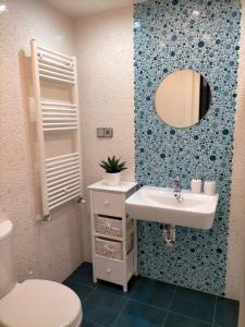 bagno con lavandino, servizi igienici e specchio di Aixa Granada a Granada