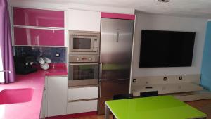 cocina con mesa verde y TV en Apartamento Climatizado Vacacional, en Vilallonga (Villalonga)