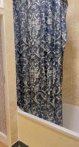 a black and white shower curtain in a bathroom at Manchester Old Trafford Apartment in Manchester