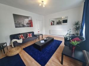 sala de estar con sofá y alfombra azul en Lovely Large London Apartment Near Stratford en Londres