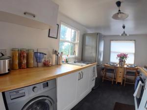 a kitchen with a sink and a washing machine at Lovely Large London Apartment Near Stratford in London