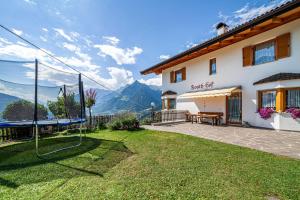a house with a lawn in front of it with mountains at Roath Hof Ferienwohnung 2 in Schenna