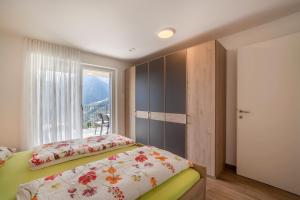 Schlafzimmer mit einem Bett und einem Fenster in der Unterkunft Panoramawohnung Bergerweg in Schenna