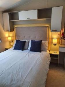 a bedroom with a large white bed with blue pillows at K17 Lake View in Paignton