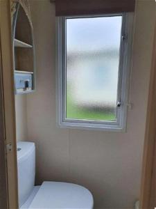 a bathroom with a white toilet and a window at K17 Lake View in Paignton