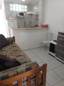 Zimmer mit einer Küche mit einem Tisch und einem Bett in der Unterkunft Flat em Pitangueiras - Guarujá in Guarujá