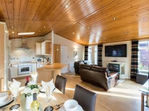 a kitchen and living room with a wooden ceiling at Windermere Retreat - White Cross Bay Holiday Park in Windermere