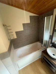 a bathroom with a tub and a sink at Windermere Retreat - White Cross Bay Holiday Park in Windermere