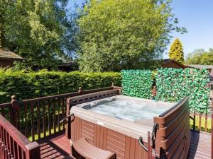 a hot tub on a deck with two chairs at Windermere Retreat - White Cross Bay Holiday Park in Windermere