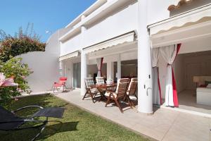een patio met stoelen en een tafel op een huis bij Large apartment in Vale do Lobo in Almancil