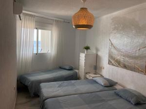 1 dormitorio con 2 camas y lámpara de araña en Piso con vistas increibles del mar, en Almuñécar