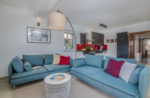 a living room with two blue couches and a table at Apartments by the sea Malinska, Krk - 19227 in Malinska
