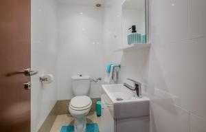 a white bathroom with a toilet and a sink at Apartments by the sea Malinska, Krk - 19227 in Malinska