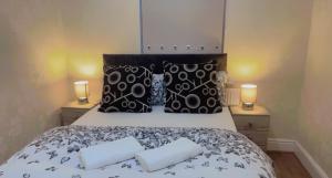 a bedroom with a bed with two pillows and two candles at Manchester Old Trafford Apartment in Manchester
