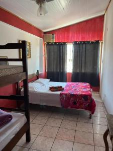 a bedroom with two bunk beds and red walls at Vibe Hostel Paraty in Paraty