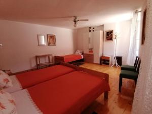 a living room with a red bed and a couch at Triple Room Plomin Luka 15078c in Plomin