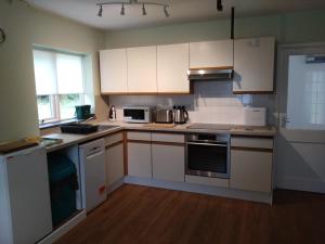 a kitchen with white cabinets and white appliances at Avryn - Delightful 3 bedroom cottage with stunning vistas in Mainstone