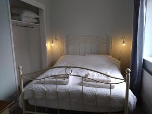 a small bedroom with a bed with white sheets at Avryn - Delightful 3 bedroom cottage with stunning vistas in Mainstone