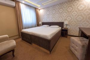 a bedroom with a bed and a chair and a table at Apartments Depandans by Djokovic in Kragujevac +7 photos