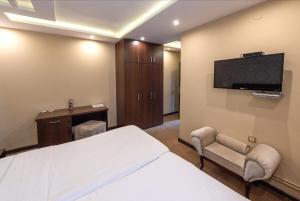 a hotel room with a bed and a flat screen tv at Apartments Depandans by Djokovic in Kragujevac