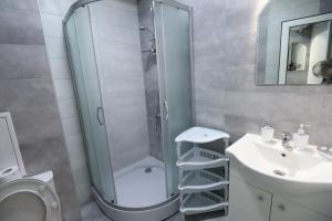 y baño con ducha, aseo y lavamanos. en Green Gardens Apartment by LMG en Sofía