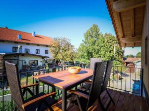 y balcón con mesa y sillas de madera. en Ferienwohnungen Koller, en Bad Aibling