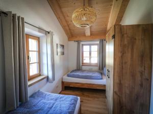1 dormitorio con 2 camas y lámpara de araña en Ferienwohnungen Koller, en Bad Aibling