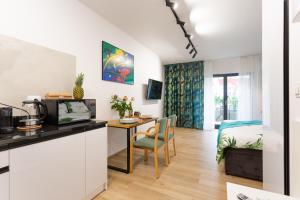 eine Küche und ein Wohnzimmer mit einem Schreibtisch und einem Bett in der Unterkunft LuxuryCity Apartment with Terrace in Breslau