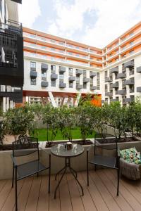 eine Terrasse mit einem Tisch und Stühlen sowie ein Gebäude in der Unterkunft LuxuryCity Apartment with Terrace in Breslau