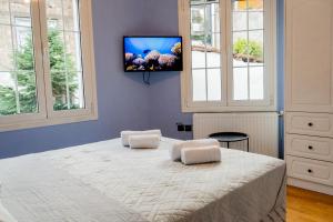 a bedroom with a large bed with a tv on the wall at Μοντέρνο Σπίτι στην καρδιά του κάστρου Ιωαννίνων in Ioannina