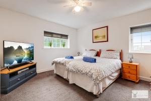 um quarto com uma cama e uma televisão de ecrã plano em Silver Stag Properties Large 4 bed Property em Markfield